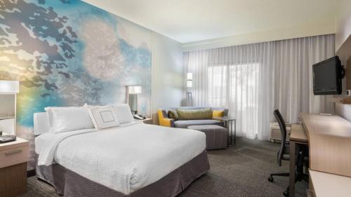 Habitación de hotel con cama, escritorio y ordenador en Courtyard by Marriott Wilmington/Wrightsville Beach, en Wilmington