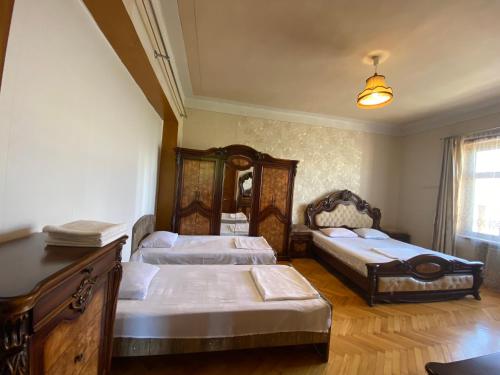 a bedroom with three beds and a mirror at Valiko house in Telavi in Tʼelavi