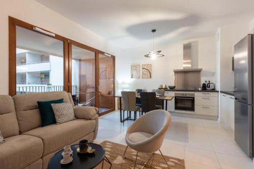 un salon avec un canapé et une cuisine dans l'établissement Le Conflu Home - En plein cœur de la Confluence, à Lyon