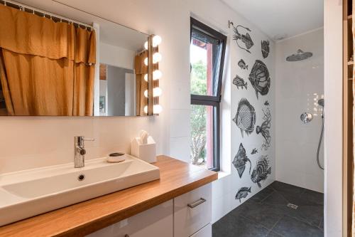 un bagno con lavandino e specchio di Villa Valle di Corte - Avec piscine et vue mer a Pianottoli-Caldarello