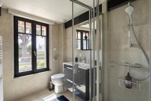 een badkamer met een douche, een toilet en een wastafel bij La Fleur du Moulin - Charmante maison avec jardin proche plage in Saint-Briac-sur-Mer