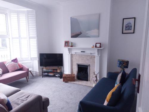 a living room with two couches and a fireplace at LetAway - Yonge's Place Saltburn in Saltburn-by-the-Sea