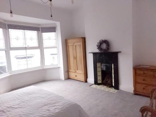 a white bedroom with a bed and a fireplace at LetAway - Yonge's Place Saltburn in Saltburn-by-the-Sea