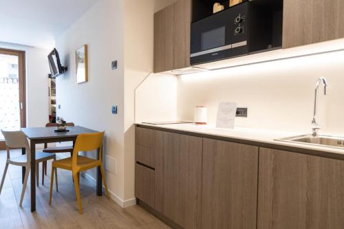 a small kitchen with a table and a sink at Olimpia Hotel in Bormio