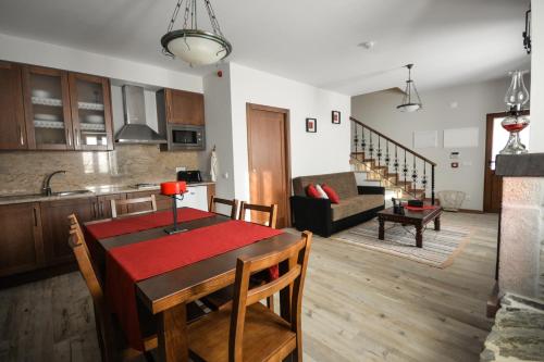 a kitchen and a living room with a table and chairs at Casas no Terreiro in Penacova