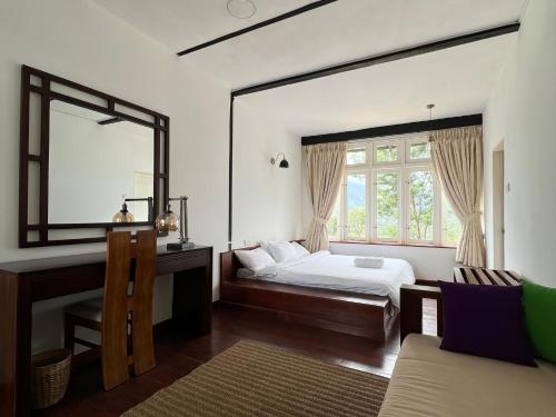 a bedroom with a bed and a large window at The Farmhouse Mahaulpatha in Bandarawela