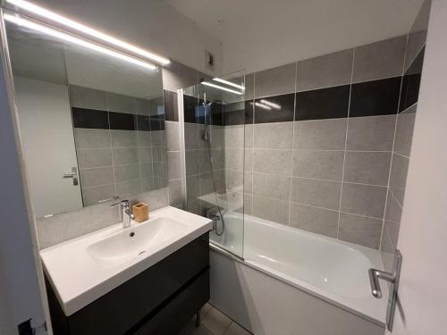 ein Badezimmer mit einem Waschbecken, einer Badewanne und einem Spiegel in der Unterkunft Proche mer Gassin Appartement t2 pour 6 personnes N2 035 in Gassin