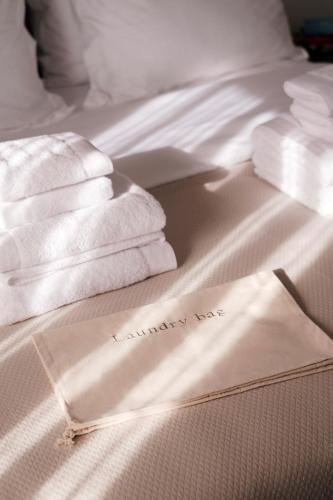a pile of towels on a bed with a sign on it at Sigma Residences Boutique Hotel in Exámbela