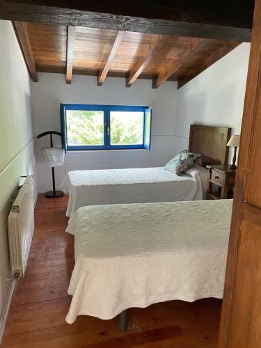 a bedroom with two beds and a window at CASA EL PELAMBRE 