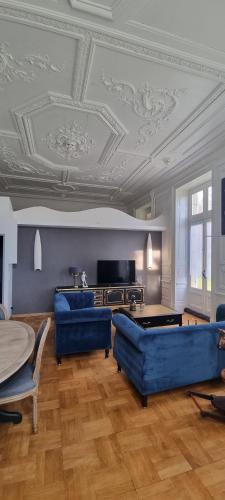uma sala de estar com mobiliário azul e um tecto em caixote em Ma petite folie 