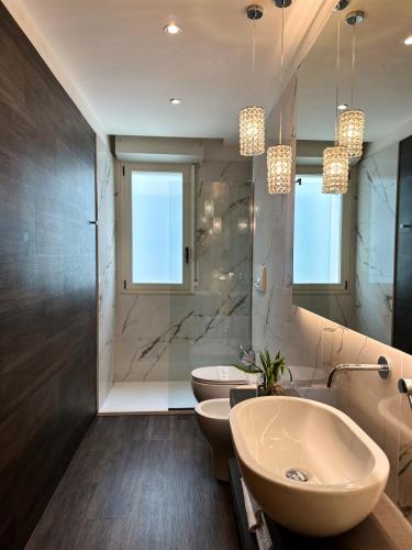a bathroom with a sink and two toilets at Residence Lungomare - Charming apartments in Riccione