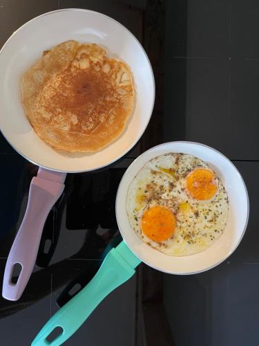 two plates of food with eggs and bread on a table at De Horizon in Bullange