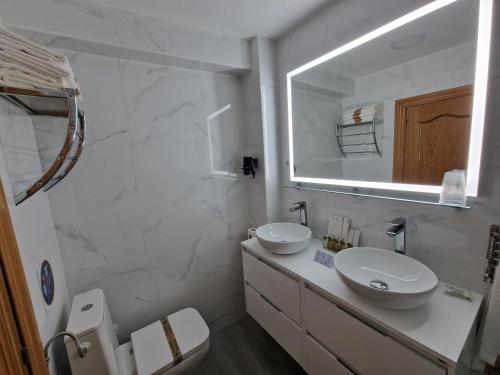 a white bathroom with a sink and a mirror at Hostal Fidalgo in Oviedo