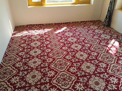 alfombra roja y blanca en el suelo de una habitación en OYO Home Shugufta Villa Homestay en Gāndarbal