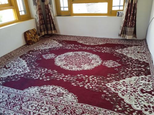 un tappeto rosso sul pavimento in una stanza di OYO Home Shugufta Villa Homestay a Gāndarbal