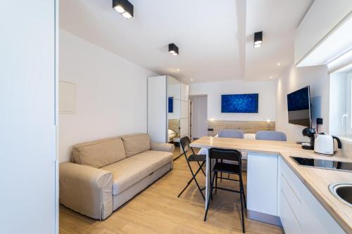 a kitchen and living room with a couch and a table at Apartments Ema in Rogotin