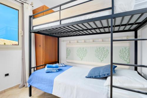 a bedroom with a bunk bed with blue pillows at Villetta Azzurro - SHERDENIA Luxury Apartments in Marinella