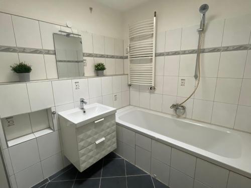 ein Badezimmer mit einer Badewanne, einem Waschbecken und einer Badewanne in der Unterkunft "Live Good, Work Good" - Stadion Apartment by GG Rental Hamburg in Hamburg