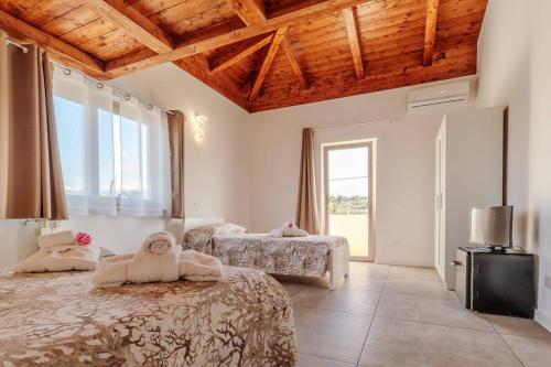 a bedroom with two beds and a large window at Residenza Anna Calabria in Briatico