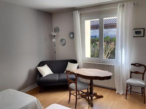un salon avec un canapé, une table et une fenêtre dans l'établissement Maison la teste centre, à La Teste-de-Buch