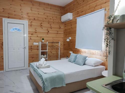 una camera con letto bianco e pareti in legno di Elafonisos Loft A3 a Elafónisos