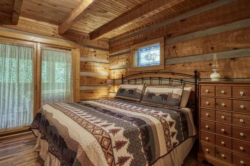 1 dormitorio con 1 cama en una cabaña de madera en Lover's Hideaway #1616, en Sevierville