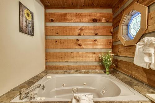 y baño con bañera y paredes de madera. en Lover's Hideaway #1616, en Sevierville