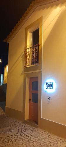 a white building with a balcony and a door at A Casa do Maltês in Belver