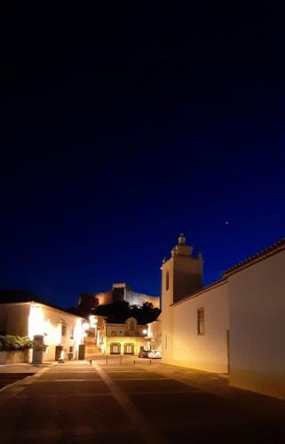 a building with a clock tower at night at A Casa do Maltês in Belver