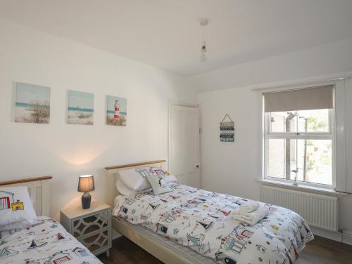 a bedroom with two beds and a window at The Old School House in Bodorgan