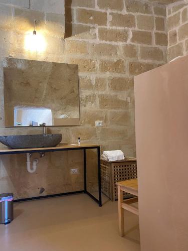 a bathroom with a sink and a mirror at 5 Elementi Sassi Matera in Matera