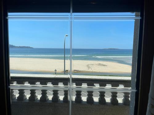 a view of the beach from a window at PLAYA AMERICA MAR in Nigrán