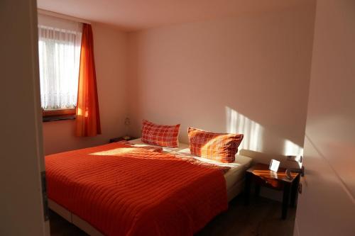 una camera da letto con un letto con lenzuola rosse e una finestra di FEWO am See Zarrendorf a Zarrendorf