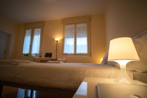 a bedroom with a bed with a lamp on a table at Casa dello Studente in Vittorio Veneto