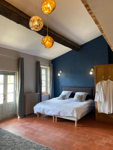 a bedroom with a bed and blue walls at La Maison de La Tour Pinte in Carcassonne