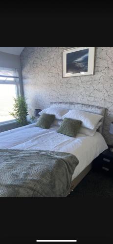 a bedroom with a large white bed with pillows at Sea View Terrace in Donaghadee