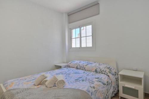 Bonito apartamento a 100 m de la playa في Arico: غرفة نوم بيضاء مع سرير ونافذة