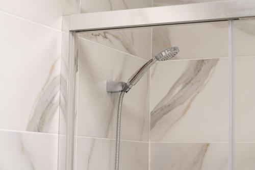 Bonito apartamento a 100 m de la playa في Arico: دش في حمام مع رأس دش