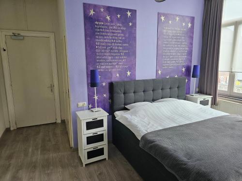 a bedroom with a bed and a purple wall with stars at hotel le bonheur in Eijsden