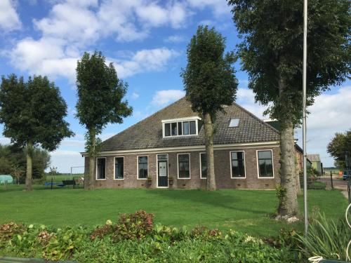 a house with two trees in front of it at Vakantiehuis Overleek in Monnickendam