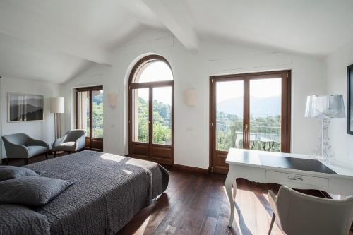 トレメッツォにあるVilla Fiordalisoのベッドルーム1室(ベッド1台、デスク、窓付)