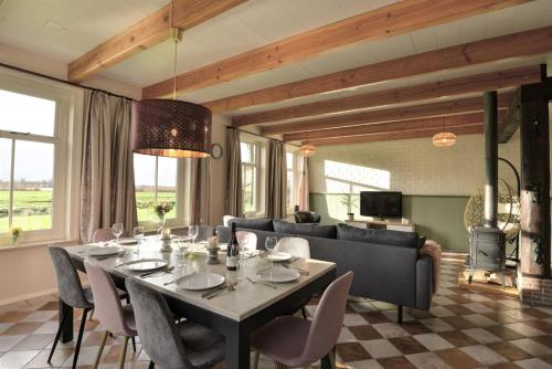 a dining room with a table and a couch at Vakantiehuis Overleek in Monnickendam
