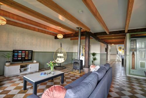 a living room with a blue couch and a tv at Vakantiehuis Overleek in Monnickendam