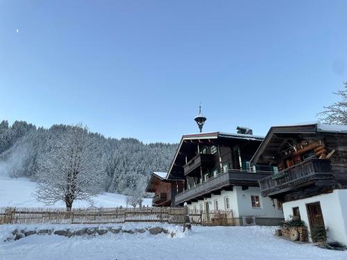 a large building with snow on the ground at Obinghof in Fieberbrunn