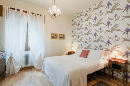 a bedroom with a white bed with a floral wallpaper at Casa Panoramica - by My Home In Como in Como