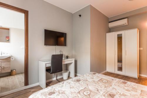 een slaapkamer met een bureau en een televisie aan de muur bij Amelia 5 in Rome