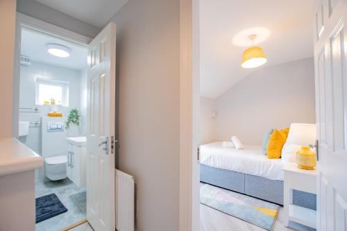 a white bedroom with a bed and a bathroom at Cozy Retreat in The City Centre in Galway