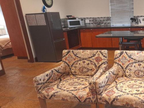 Una sala de estar con un sofá y una cocina. en Paddabult Self Catering Cottages, en Paarl