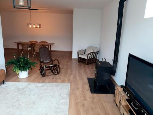 a living room with a television and a table and chairs at Retiro da Cava, piscina privada in Oleiros