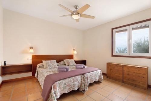 una camera con letto e ventilatore a soffitto di La Calabacera Casa Verde con piscina, By Paramount Holidays a Guía de Isora